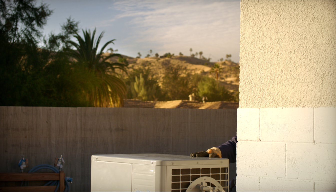 Outdoor AC condenser at a residential home in Jurupa Valley, California with palm trees and Santa Ana River corridor - JC Energy Solutions