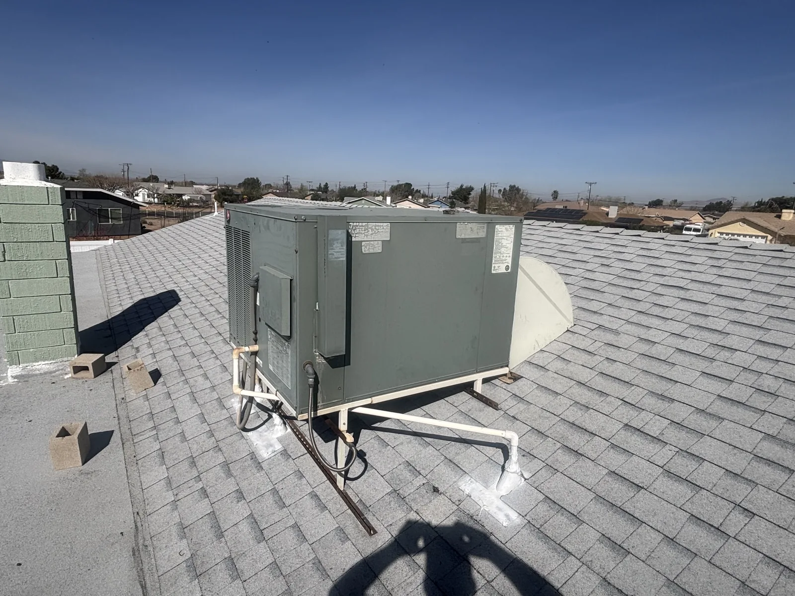 JC Energy Solutions rooftop packaged HVAC unit installed on a High Desert home with the valley and San Bernardino mountains behind it