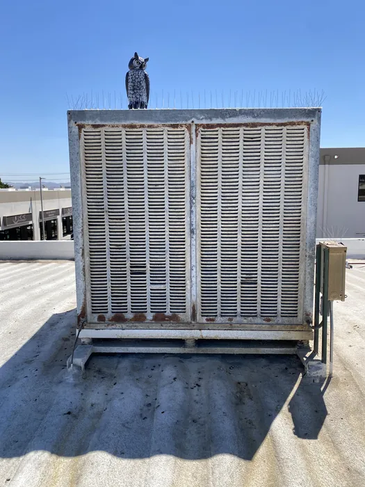 Front view of a rooftop commercial HVAC package unit with large condenser coil grille on a flat commercial roof in the High Desert.