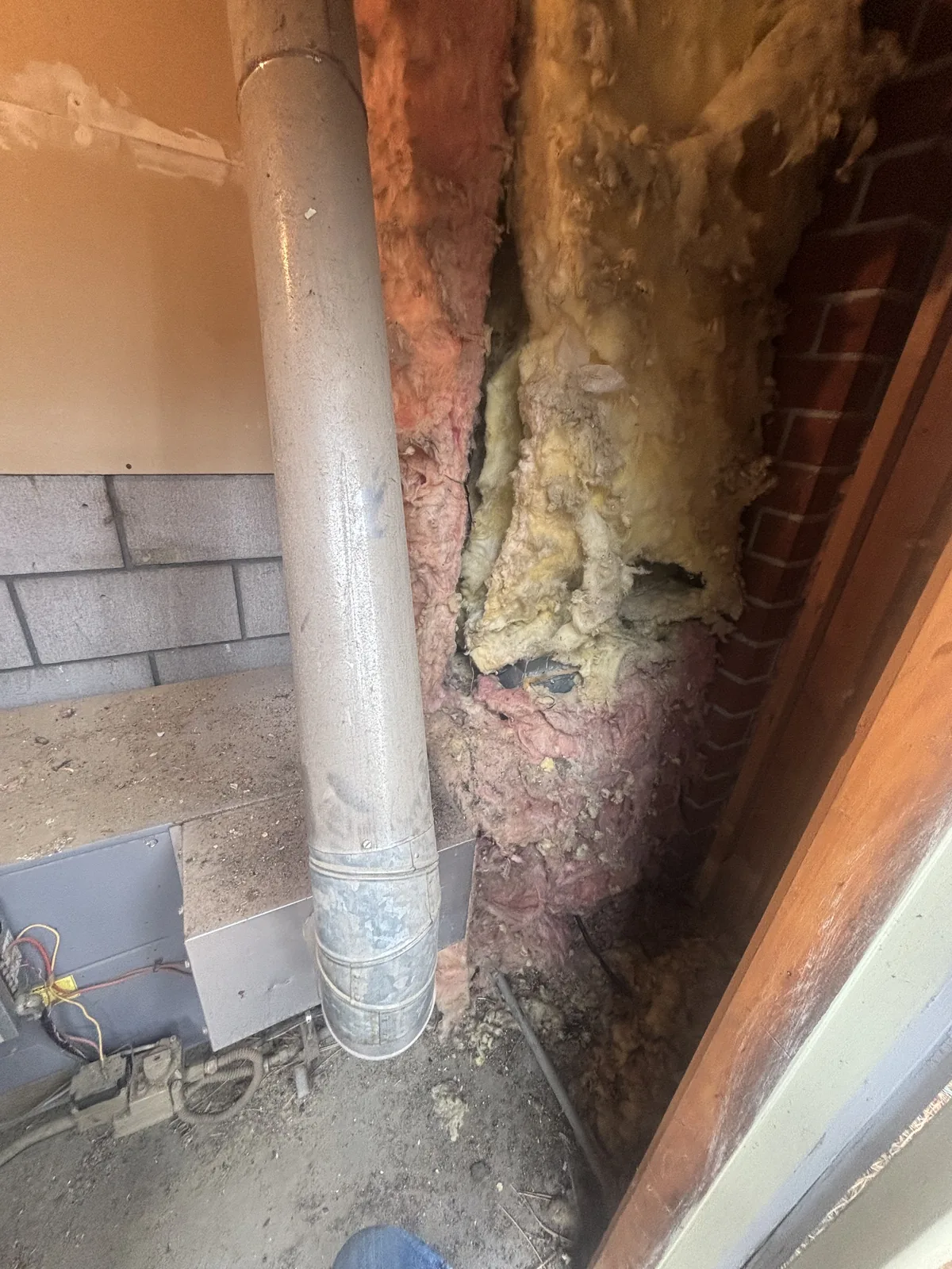 Deteriorated old duct insulation and metal ducting exposed in a tight crawlspace during an HVAC ductwork inspection in the Inland Empire.