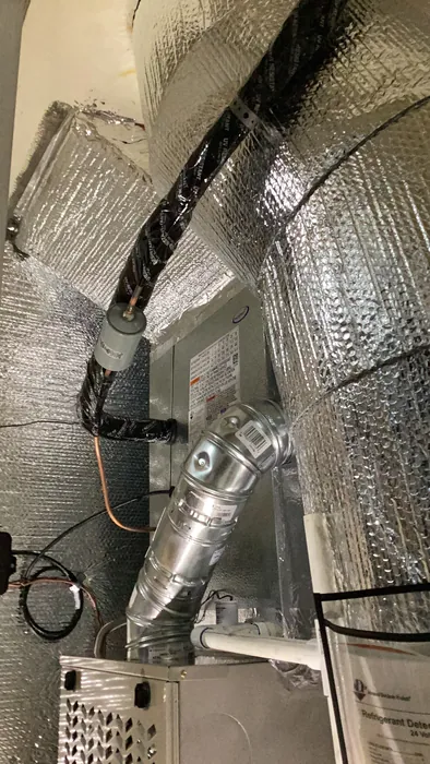 Carrier air handler with insulated flex duct connected to a sheet metal plenum and galvanized supply trunk inside a High Desert garage