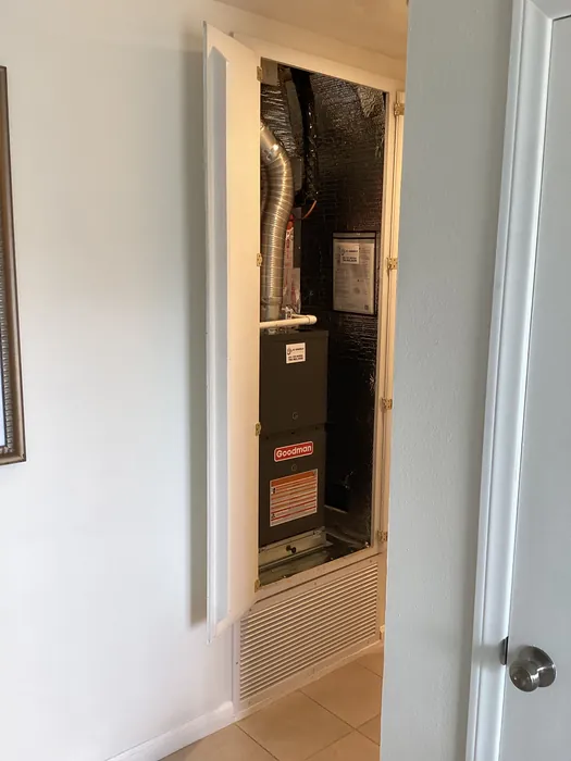 Goodman air handler unit installed inside a hallway ceiling closet next to a return air grille in a High Desert home.