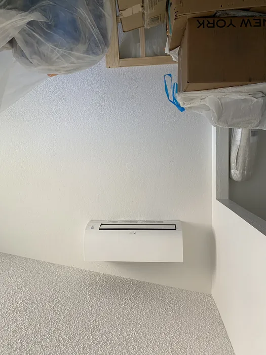 Daikin mini split indoor wall head freshly mounted on a white wall during a High Desert home install with moving boxes nearby.