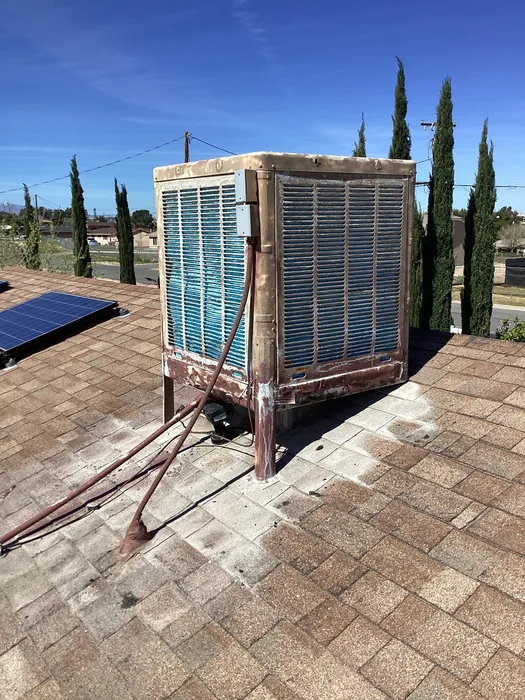 Close-up of a rooftop evaporative cooler showing its cooling media pad panels on an Inland Empire home roof.