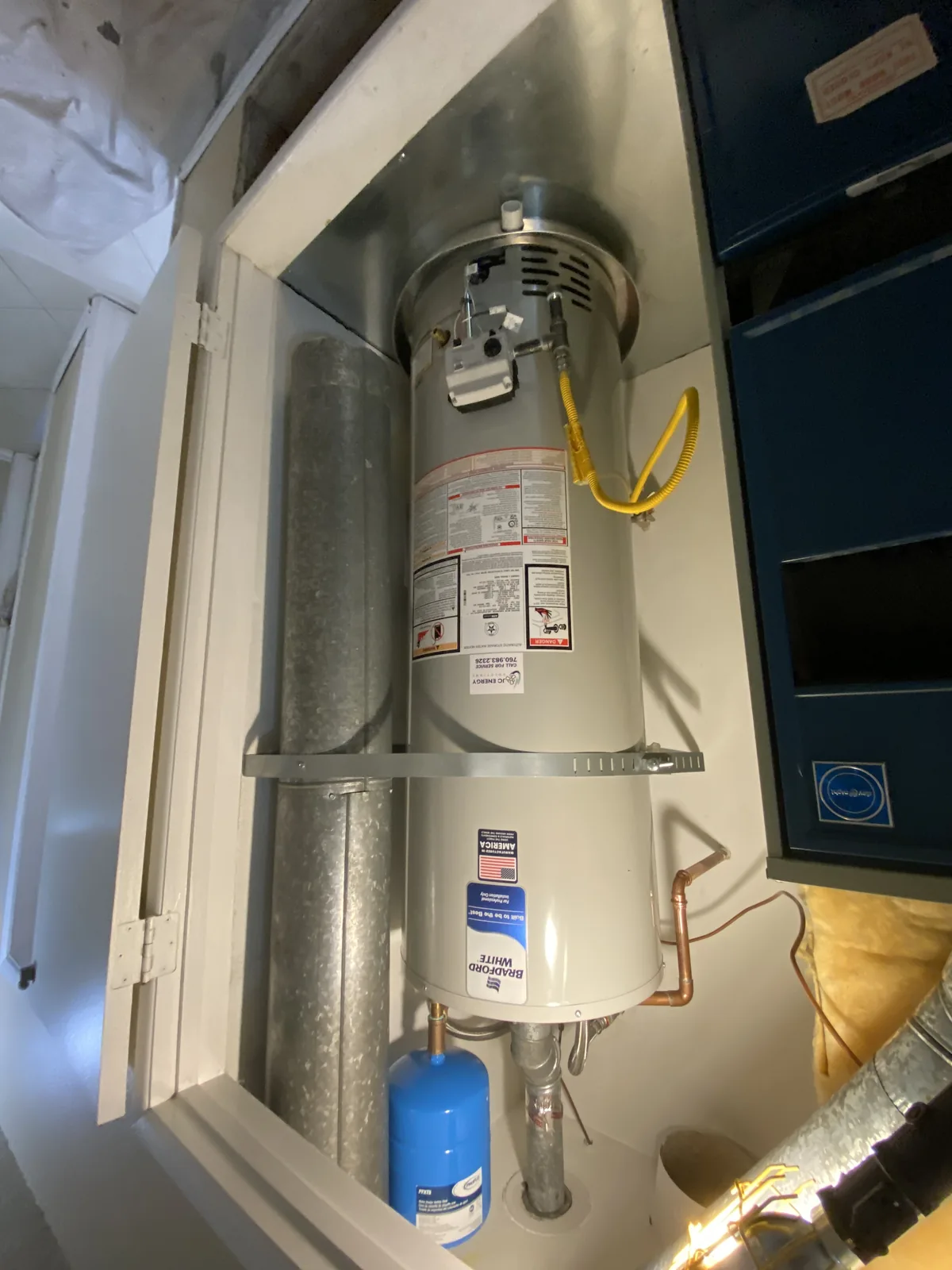 Bradford White gas water heater with a JC Energy service sticker installed in a utility closet next to the air handler in the High Desert.