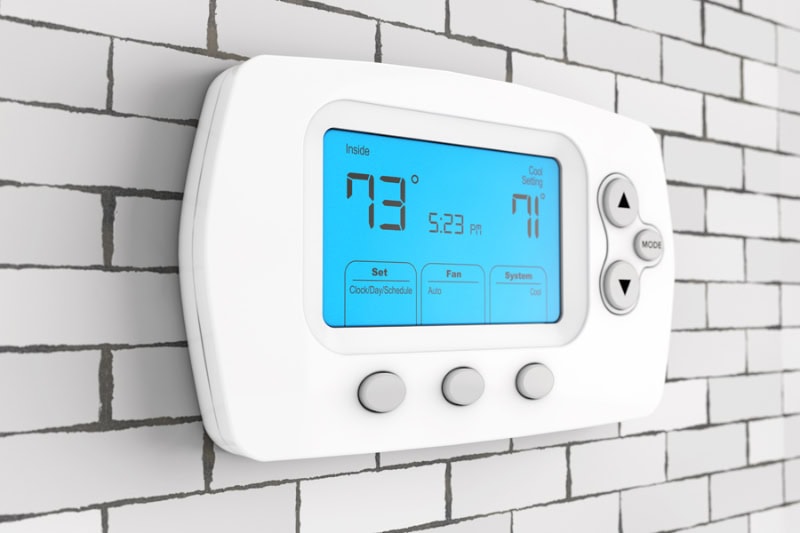 A modern programming thermostat on a wall